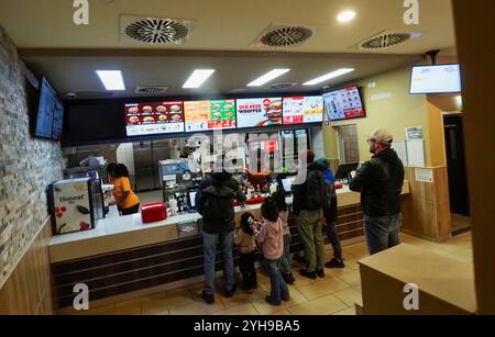 I clienti del ristorante Burger King aspettano che il loro cibo sia preparato Foto Stock