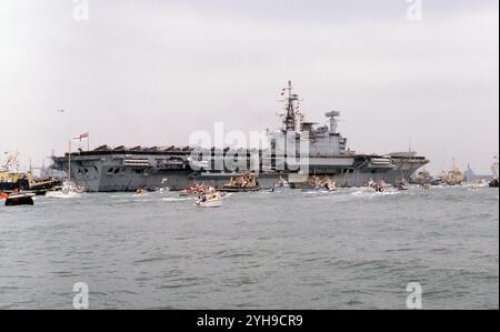 Circondata da barche, la HMS Hermes torna dalle Falklands al porto di Portsmouth Foto Stock