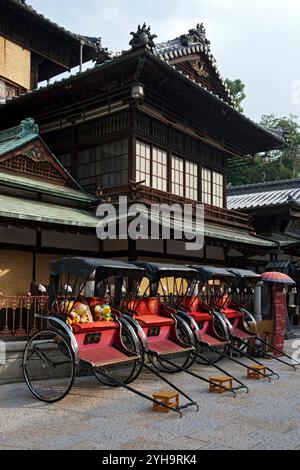 Risciò di fronte all'"honkan", o edificio principale, presso le terme termali Dogo Onsen a Matsuyama, Ehime, il più antico onsen del Giappone. Foto Stock