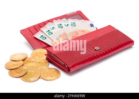 Aperto Red Women Purse con 10 Euro banconote all'interno e Bitcoin Coins - isolato su sfondo bianco. Un portafoglio pieno di soldi che simboleggia ricchezza, successo, shopping e status sociale - isolamento Foto Stock