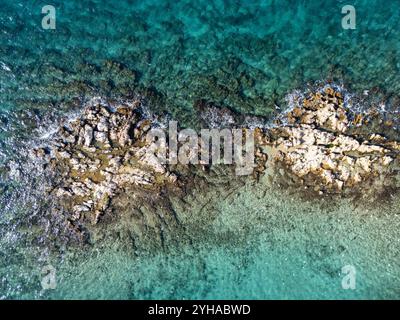 Scogliere in mezzo al mare dall'alto, scatta foto da un drone in una giornata di sole Foto Stock