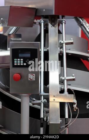 Primo piano automatico della macchina per il rotolamento dell'impasto conico. Messa a fuoco selettiva. Foto Stock