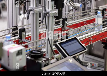 Sistema di trasporto con pannello di controllo touchscreen nell'impianto di imbottigliamento di acqua di sorgente. Messa a fuoco selettiva. Foto Stock