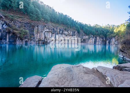 La foto mostra lo stupefacente Lac Tritriva, un lago vulcanico con acque blu vibranti, circondato da scogliere verticali di gneiss con distintivi neri e. Foto Stock