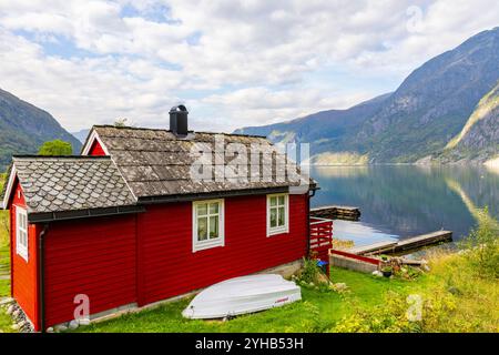 Tradizionale casa norvegese rossa sulla riva del fiordo Eid, un ramo interno dell'Hardangerfjorden nella Norvegia occidentale, Europa, 2024 Foto Stock