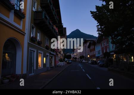 Golling an der Salzach, Austria - 14 giugno 2021: Strada costeggiata da edifici colorati e una montagna sullo sfondo in una serata primaverile a Golling Foto Stock