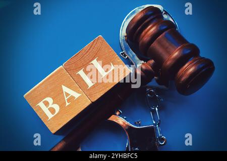 BAIL composto da cubetti di legno con martelletto su sfondo blu. Foto Stock