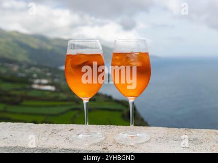 Due bicchieri di Aperol Spritz godono di vista sull'oceano Foto Stock