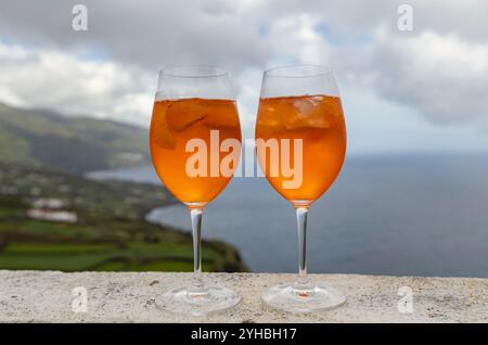 Due bicchieri di Aperol Spritz godono di vista sull'oceano Foto Stock