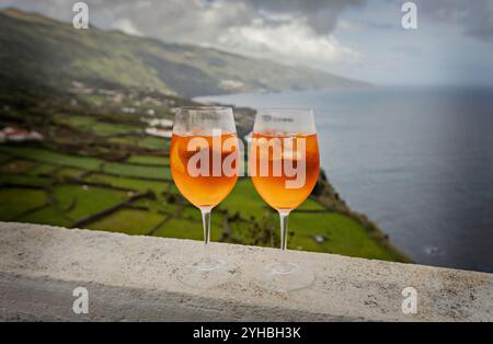 Due bicchieri di Aperol Spritz godono di vista sull'oceano Foto Stock