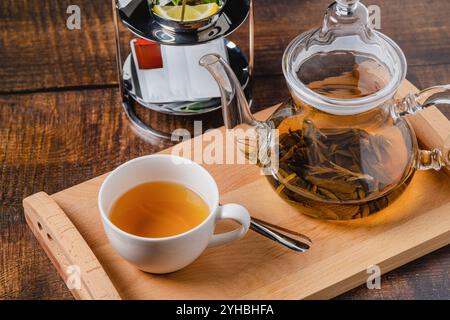 Tè alle erbe o tè al tiglio in porcellana bianca su un tavolo di legno Foto Stock