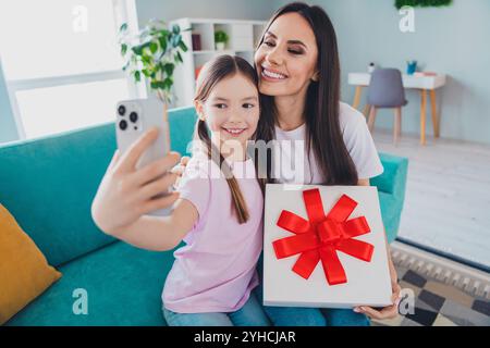 Foto di una simpatica e adorabile mamma con la figlia che festeggia la festa della mamma scatta un selfie in casa Foto Stock