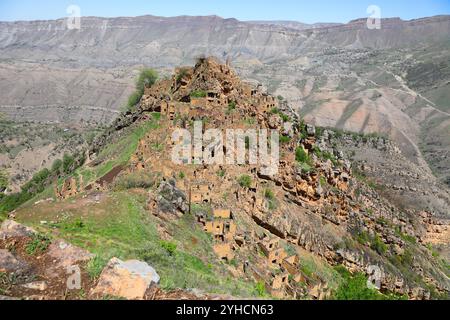 Rovine dell'antico villaggio di Gamsutl con muri in pietra abbandonati in cima alla vetta della montagna durante il giorno di sole nel Daghestan, Russia Foto Stock