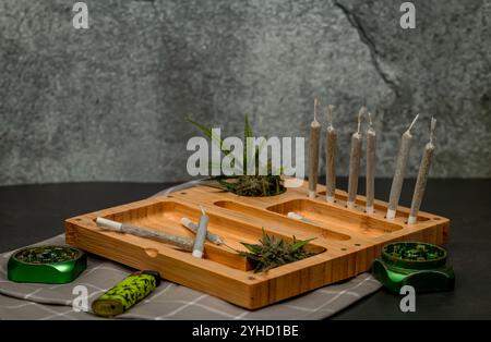 Scatola in legno di colore chiaro con articolazioni e marijuana fresca e vecchie pareti in pietra Foto Stock