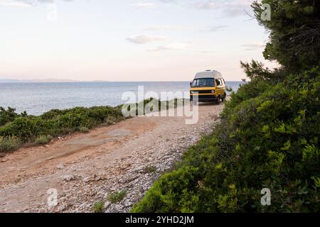 Camper giallo retrò parcheggiato su una strada sterrata sopra il mare sull'isola di Korcula, Croazia Foto Stock