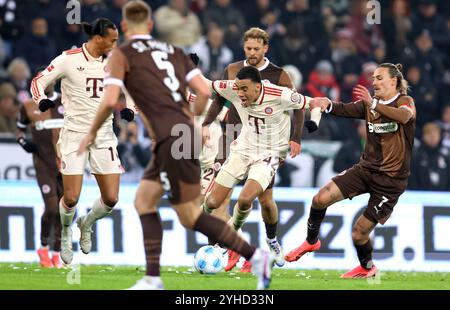 AMBURGO, GERMANIA - 9 NOVEMBRE: Jamal Musiala del Bayern Muenchen , Jackson Irvine von FC St. Pauli durante la partita di Bundesliga tra FC St. Pauli 1910 e FC Bayern München al Millerntor Stadium il 9 novembre 2024 ad Amburgo, Germania. © diebilderwelt / Alamy Stock Foto Stock