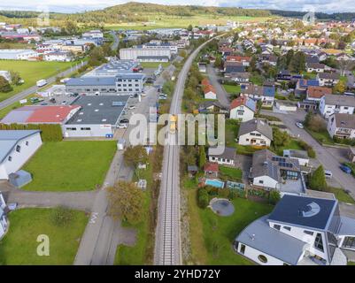 Vista aerea di un binario ferroviario attraverso un'area mista con edifici residenziali e commerciali, macchina per compattazione, Hermann Hessebahn, Althengstett, Black Foto Stock