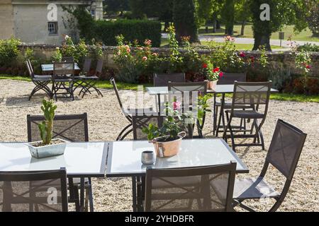 Tavoli decorati con fiori nel cortile del castello Grand Mello. Francia. Giornata di sole ad agosto Foto Stock