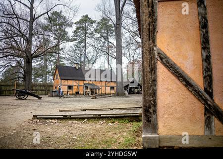 JAMESTOWN, Virginia - il ricostruito James Fort presso l'insediamento di Jamestown presenta caratteristici edifici di wattle e daub di colore arancione disposti lungo sentieri sterrati. La struttura del forte mostra la tipica architettura coloniale inglese dei primi anni del XVII secolo e la pianificazione degli insediamenti. La disposizione dell'edificio riflette le considerazioni difensive e pratiche del forte originale all'interno delle sue pareti triangolari della palizzata. Foto Stock