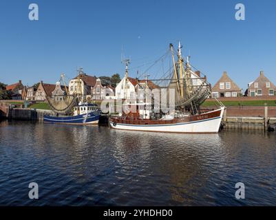 Storiche case di pescatori in mattoni a timpano a Sielstrasse con taglierine di gamberi nel porto di Greetsiel, Greetsiel, Krummhoern, Mare del Nord, Frisia orientale, abbassamento Foto Stock