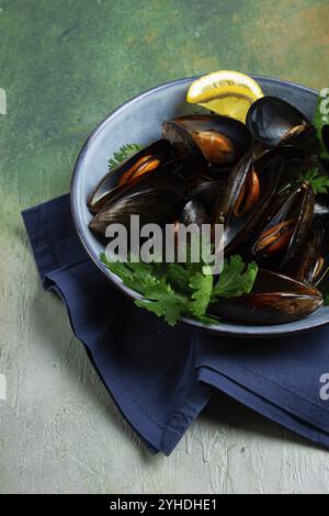 Cozze in conchiglie, bollite nel loro succo, in una ciotola, vista dall'alto, fatte in casa, niente persone Foto Stock