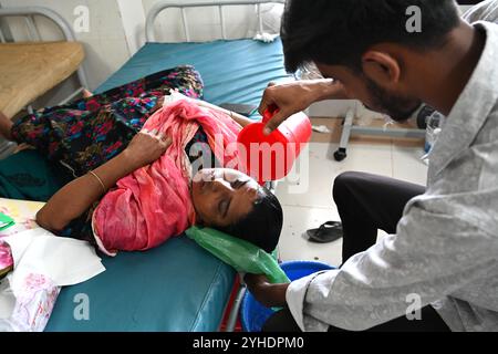 Dacca, Bangladesh. 11 novembre 2024. Un parente versa acqua sulla testa di un paziente affetto da dengue che soffre di febbre dengue riposa all'interno dell'ospedale "Shaheed Suhrawardy" Medical collega di Dhaka, Bangladesh, l'11 novembre 2024. Dal 1° gennaio 2024 all'11 novembre 2024, un totale di 75.142 persone sono state colpite dalla dengue. Almeno 310 persone sono morte nel peggiore focolaio di dengue del Bangladesh mai registrato, hanno detto i funzionari l'11 novembre, mentre gli ospedali sovraccarichi lottano per curare migliaia di pazienti. Crediti: Mamunur Rashid/Alamy Live News Foto Stock