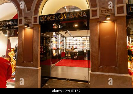 Verona, Italia - 8 dicembre 2017: Assistente del negozio che organizza borse firmate all'interno di un negozio di dolci e gabbana illuminato in un edificio storico in Foto Stock