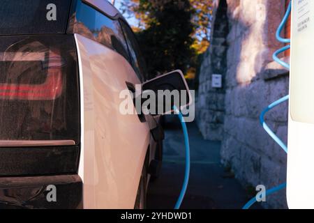 Ricarica del veicolo elettrico presso una stazione Foto Stock