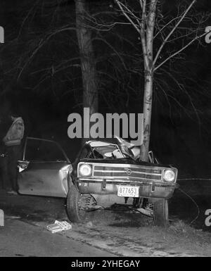 Scena di incidente con una proverbiale auto avvolta intorno a un proverbiale albero, circa 1970 anni Foto Stock