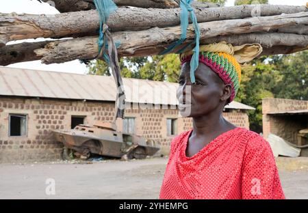 SUDAN DEL SUD, Stato dei Laghi, Rumbek, caserma abbandonata dell'esercito sudanese, vecchio carro ammuffito dalla guerra tra SPLA e esercito sudanese, donna portare legni da fuoco / SÜDSUDAN, Stato dei Laghi, Stadt Rumbek, alte Kaserne und alter Schützenpanzer der nordsudanesischen Armee aus dem Krieg mit der SPLA Sudanesische Volksbefreiungsarmee, Frau trägt Feuerholz Foto Stock