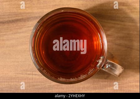 Il ricco liquido ambrato del tè appena preparato brilla alla luce del mattino, invitando un momento di tranquillità. Foto Stock