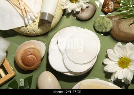 Composizione piatta con tamponi e tamponi di cotone su un tavolo verde Foto Stock