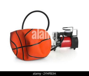 Sfera da basket sgonfiata e compressore d'aria isolato su bianco Foto Stock