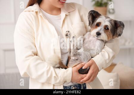 Giovane donna con il suo cane Biewer Terrier a casa, primo piano Foto Stock