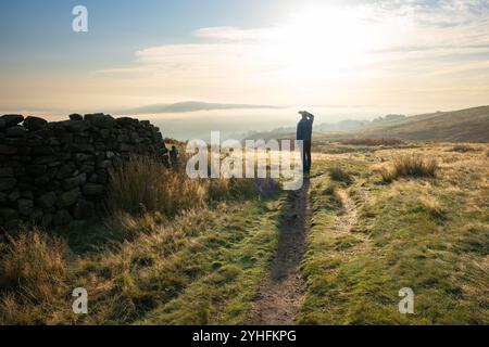 Burley Moor, Burley a Wharfedale, Ilkley, West Yorkshire, Inghilterra, Regno Unito - un uomo che guarda in basso Burley a Wharfedale si è avvolto nella nebbia mattutina Foto Stock