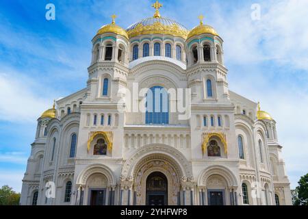 Una grande cattedrale con prominenti cupole dorate e una facciata ornata, che mostra intricati dettagli architettonici sotto un cielo blu brillante, simboleggiando il cu Foto Stock