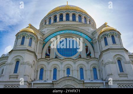 Una grande cattedrale con prominenti cupole dorate e una facciata ornata, che mostra intricati dettagli architettonici sotto un cielo blu brillante, simboleggiando il cu Foto Stock