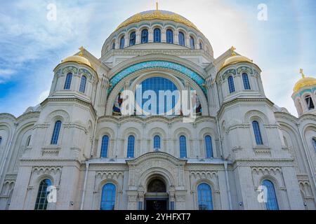 Una grande cattedrale con prominenti cupole dorate e una facciata ornata, che mostra intricati dettagli architettonici sotto un cielo blu brillante, simboleggiando il cu Foto Stock