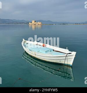 Vista tranquilla di un peschereccio bianco solitario che galleggia sulle acque calme di Nauplia, Grecia. Foto Stock
