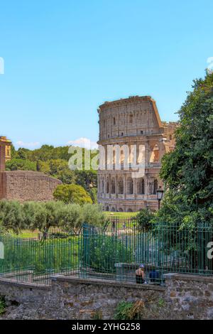 Il Colosseo di Roma, un rinomato simbolo dell'antica architettura romana, si erge su un cielo azzurro. Foto Stock