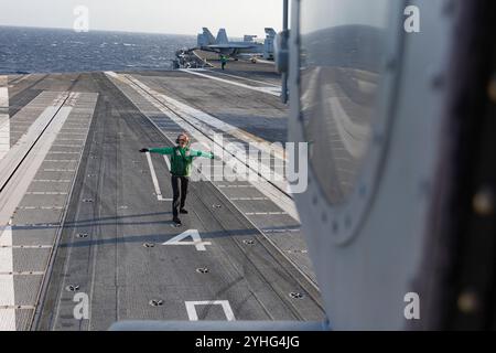 Il Mate Airman Nicole Aponte dell'Aviation Electrician, assegnato ai "Tridenti" dell'Helicopter Sea Combat Squadron (HSC) 9, dirige un MH-60S Seahawk sul ponte di volo della più grande portaerei del mondo, la USS Gerald R. Ford (CVN 78), 9 novembre 2024. Il Gerald R. Ford Carrier Strike Group è in corso nell'Oceano Atlantico completando Group Sail. Group Sail è il primo evento di formazione in fase integrata in mare durante un ciclo di addestramento all'implementazione di routine. È stato progettato per sfidare la capacità della Gerald R. Ford CSG di utilizzare le capacità della USS Gerald R. Ford (CVN 78), della USS Winston S. Churchill ( Foto Stock