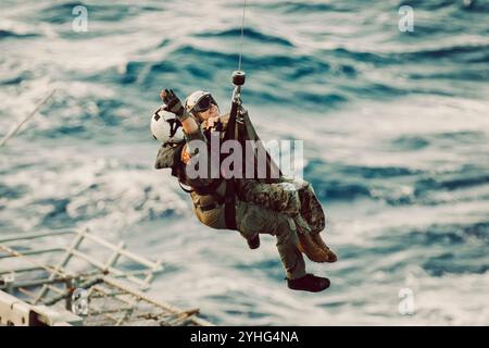 Un marinaio degli Stati Uniti ha assegnato alla Helicopter Sea Combat Squadron (HSC) 23 sollevatori il maggiore Nicole Rimal, giudice dello staff avvocato della 15th Marine Expeditionary Unit e nativa della California, dal ponte di volo della nave d'assalto anfibia USS Boxer (LHD 4) in un MH-60S Sea Hawk della Marina degli Stati Uniti durante una dimostrazione di potenza aerea a bordo della Boxer nell'Oceano Pacifico 10 novembre 2024. La manifestazione si è tenuta per celebrare il 249° compleanno del corpo dei Marines. Elementi della 15a MEU sono attualmente imbarcati a bordo della Boxer e stanno conducendo operazioni di routine nella 3a flotta degli Stati Uniti. (Foto del corpo dei Marines degli Stati Uniti Foto Stock