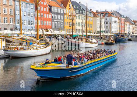 Copenhagen, persone in un tour in barca dei canali lungo il canale Nyhavn, oltre le case colorate del XVII secolo e i ristoranti in questa zona, Danimarca, 2024 Foto Stock