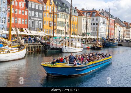 Copenhagen, persone in un tour in barca dei canali lungo il canale Nyhavn, oltre le case colorate del XVII secolo e i ristoranti in questa zona, Danimarca, 2024 Foto Stock