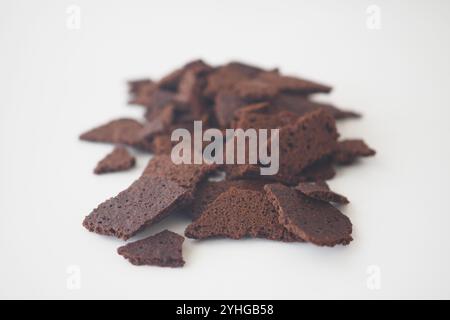 Frammenti di corteccia di cioccolato deliziosamente croccanti su sfondo bianco pulito Foto Stock