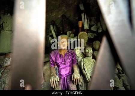 Effigi in legno all'interno di una grotta in un tradizionale sito di sepoltura nel villaggio di Kete Kesu, Tana Toraja, Sulawesi meridionale, Indonesia. Foto Stock