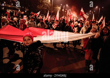 Varsavia, Polonia. 11 novembre 2024. I partecipanti portano una grande bandiera polacca durante la marcia. Cittadini polacchi provenienti da tutto il paese marciano per le strade di Varsavia per celebrare il giorno dell'indipendenza. L'evento riunisce decine di migliaia di partecipanti, con polacchi patriottici che si riuniscono per festeggiare. Molte famiglie portano i loro figli. Credito: SOPA Images Limited/Alamy Live News Foto Stock