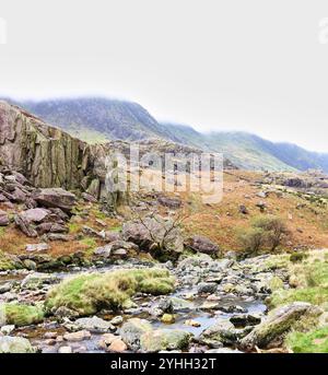 Il pendio inferiore di Yr Wyddfa (Monte Snowdon) e il torrente Nant Peris al passo Llanberis, Snowdonia, Galles, in una giornata nuvolosa. Foto Stock