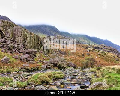 Il pendio inferiore di Yr Wyddfa (Monte Snowdon) e il torrente Nant Peris al passo Llanberis, Snowdonia, Galles, in una giornata nuvolosa. Foto Stock