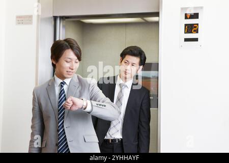 Uomo d'affari in uscita dall'ascensore Foto Stock